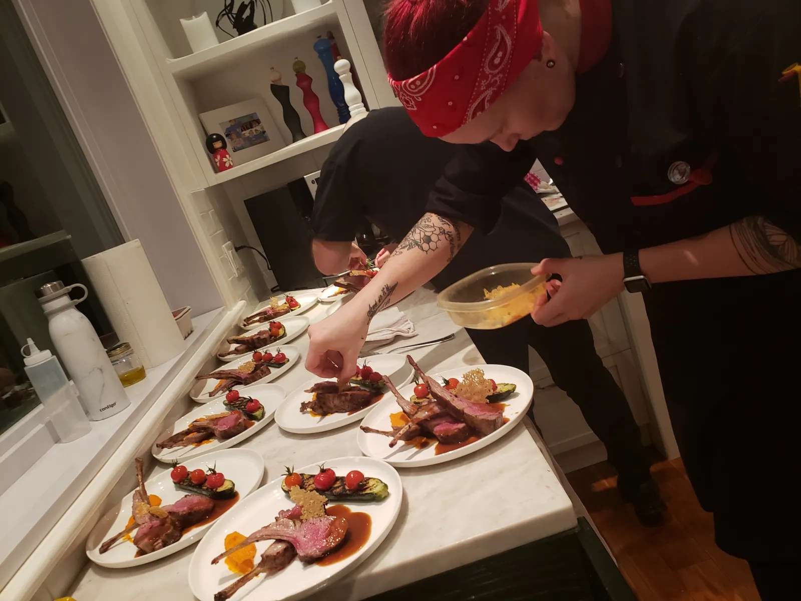 Chefs dressant des assiettes d'agneau pour un service à table